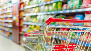 Empty grocery cart in a grocery store aisle. Consumer goods.