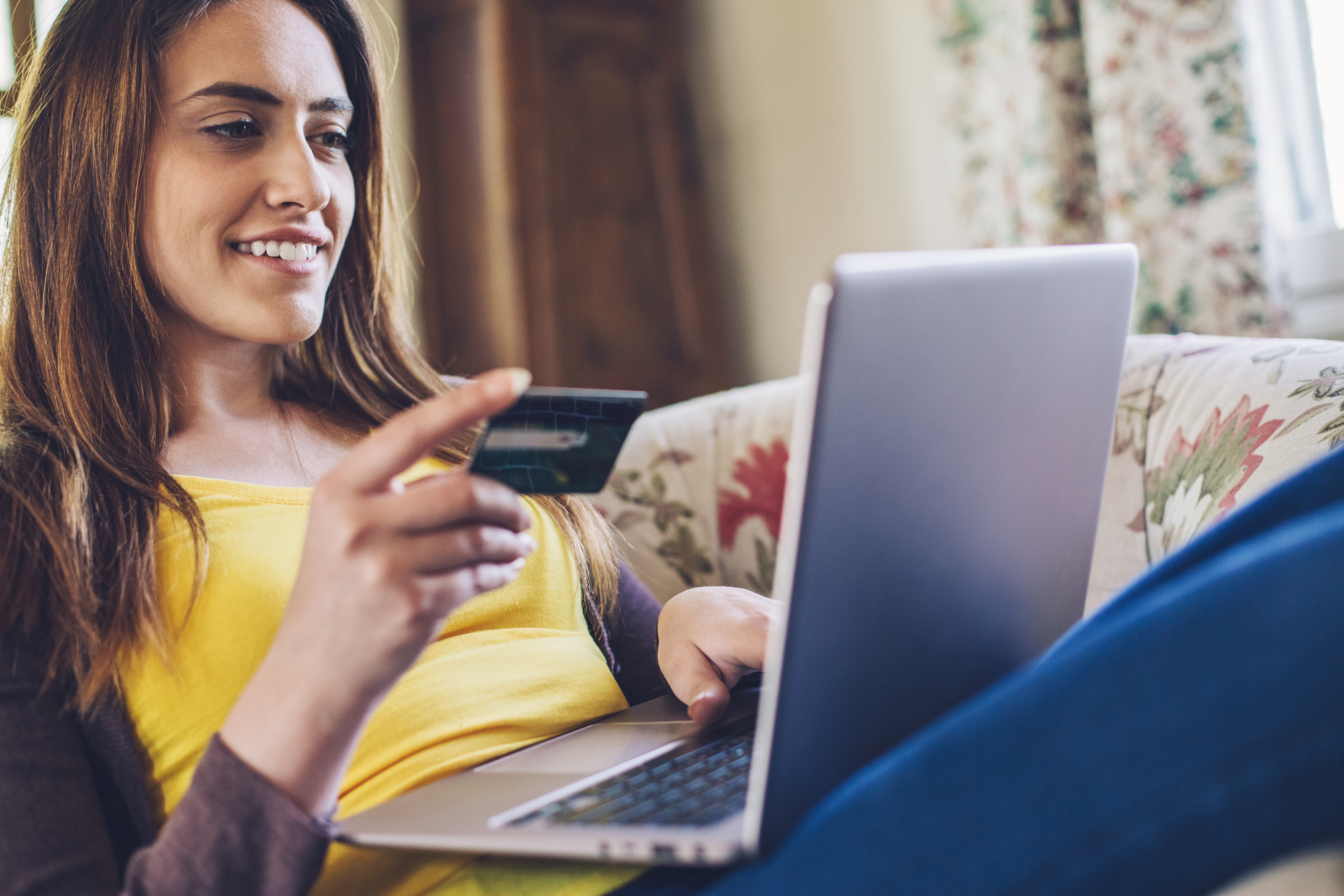 An online shopper makes a credit card purchase on a laptop computer.