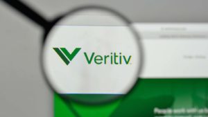 A magnifying glass zooms in on the website for Veritiv (VRTV).