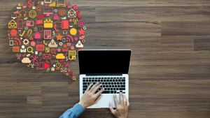 a photo of someone typing on a laptop on a wooden table with computer-related images