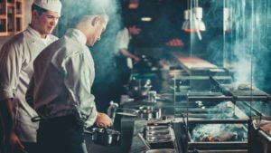 two chefs cooking in a restaurant kitchen