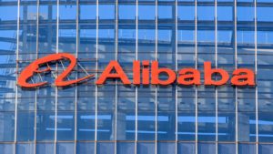 Alibaba (BABA) logo on the side of a glass-walled building.