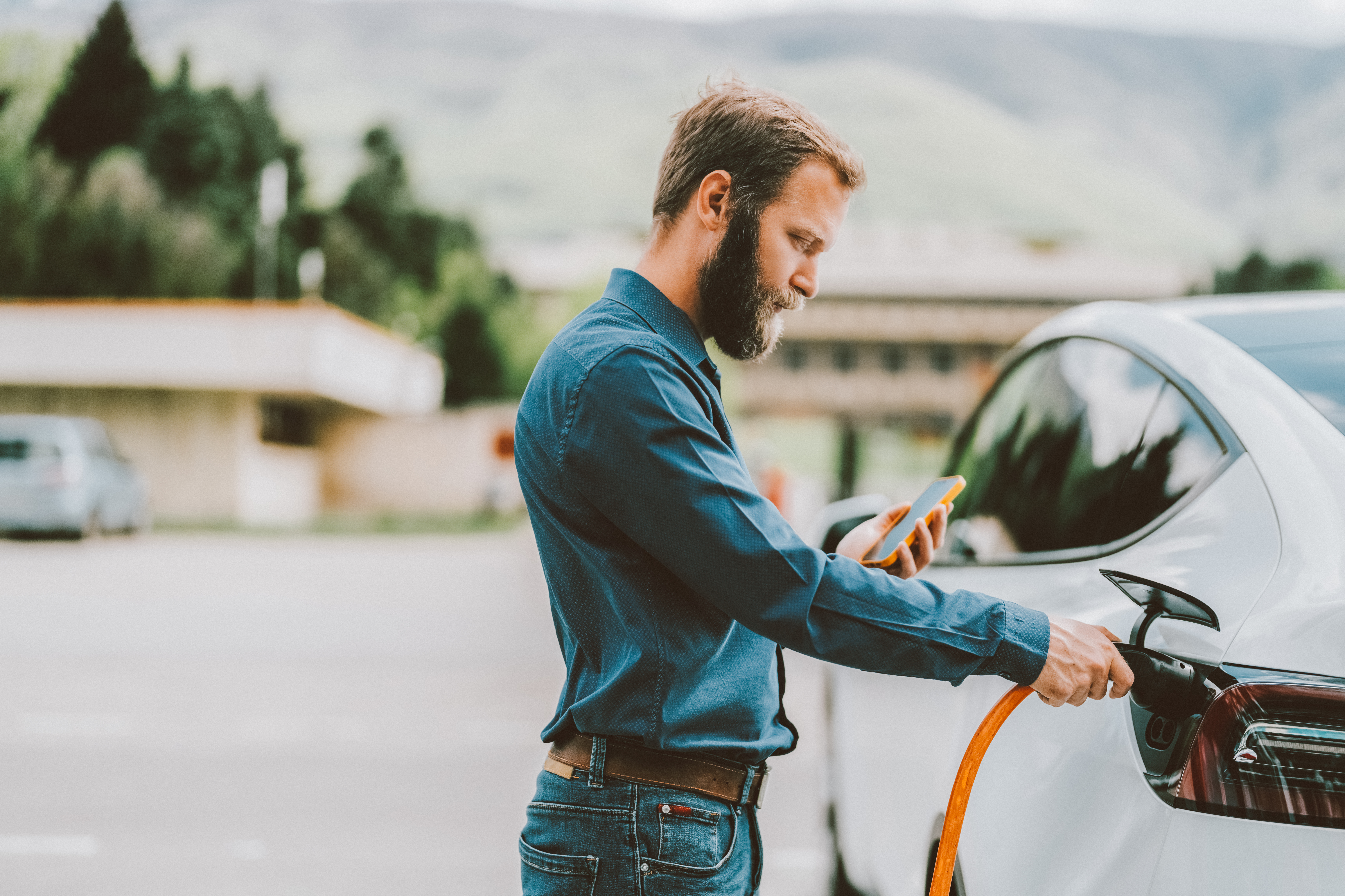 Person charging electric vehicle