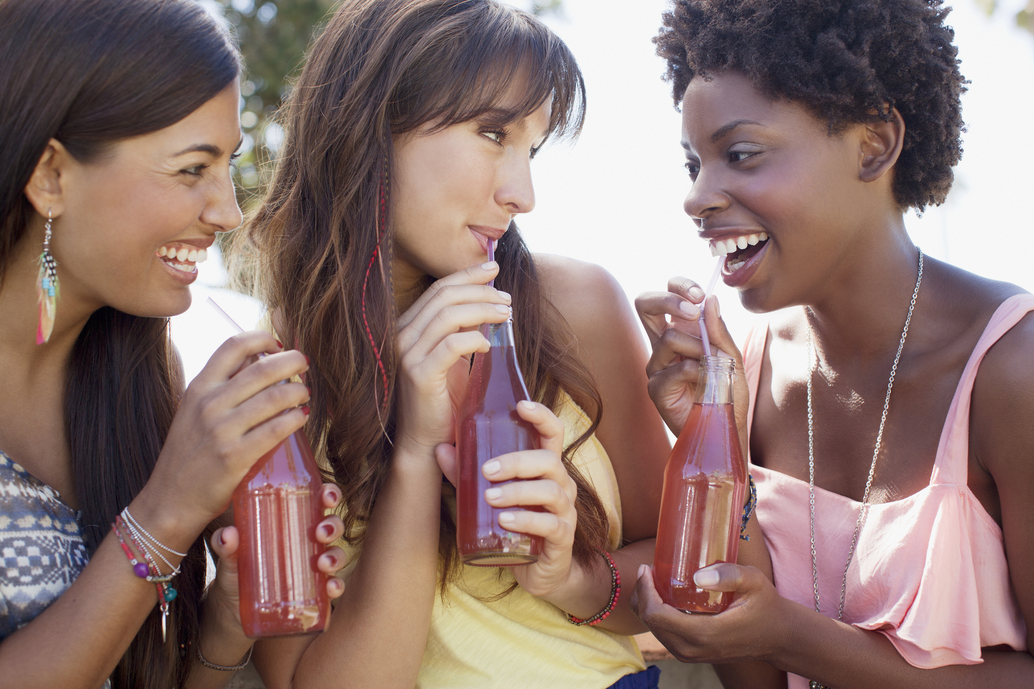 Three friends enjoying bottled beverages.