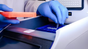 Loading a DNA tube into a PCR (polymerase chain reaction) thermocycler machine in a bioscience laboratory. Concept of science, laboratory and study of diseases. INVO stock