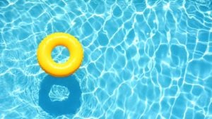 Yellow pool float, ring floating in a refreshing blue swimming pool