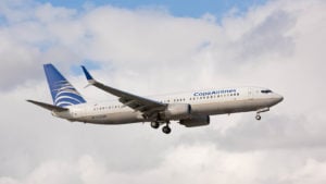 Copa plane mid-flight backdropped by white clouds. CPA stock