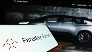 Mobile phone with logo of electric vehicle company Faraday Future Inc. on screen in front of website. Focus on center-right of phone display. Unmodified photo. FFIE stock