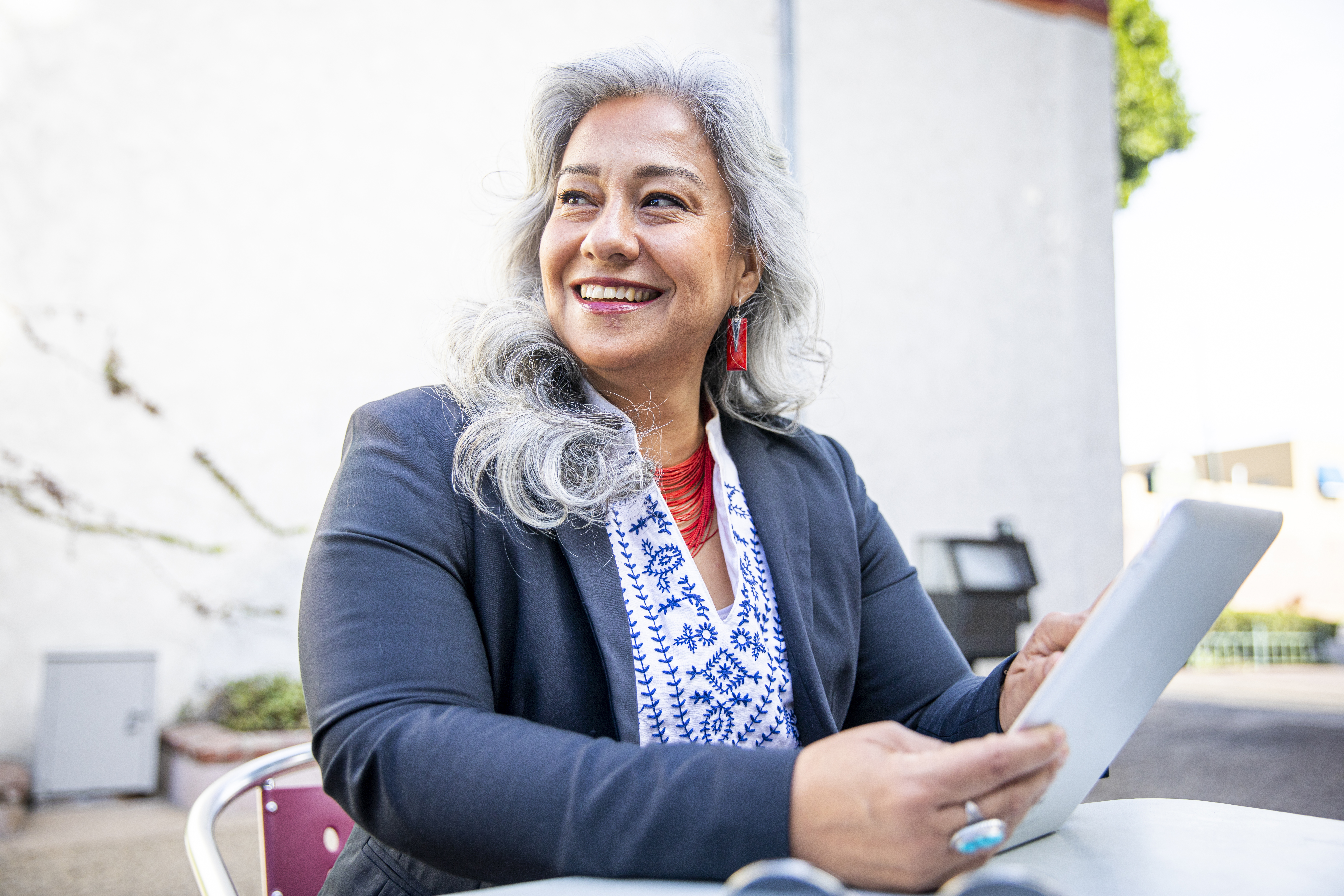 A smiling person holding a tablet.