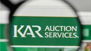 A magnifying glass zooms in on the website of KAR Auction Services (KAR).