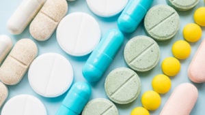 rows of pills on a table representing pharmaceutical stocks. EVAX stock