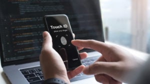 a person holding a phone with a touch id app displayed on it