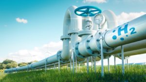 An image of a hydrogen fuel pipeline running through a grassy field, with wind turbines and solar panels in the background. top hydrogen stocks to buy