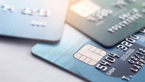 a stack of three credit cards representing payments stocks to buy