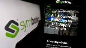 Person holding smartphone with website of US robotics warehouse company Symbotic Inc. on screen with logo. Focus on center of phone display. Unmodified photo. SYM stock