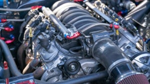 A close-up photograph of a car engine representing SINT Stock.