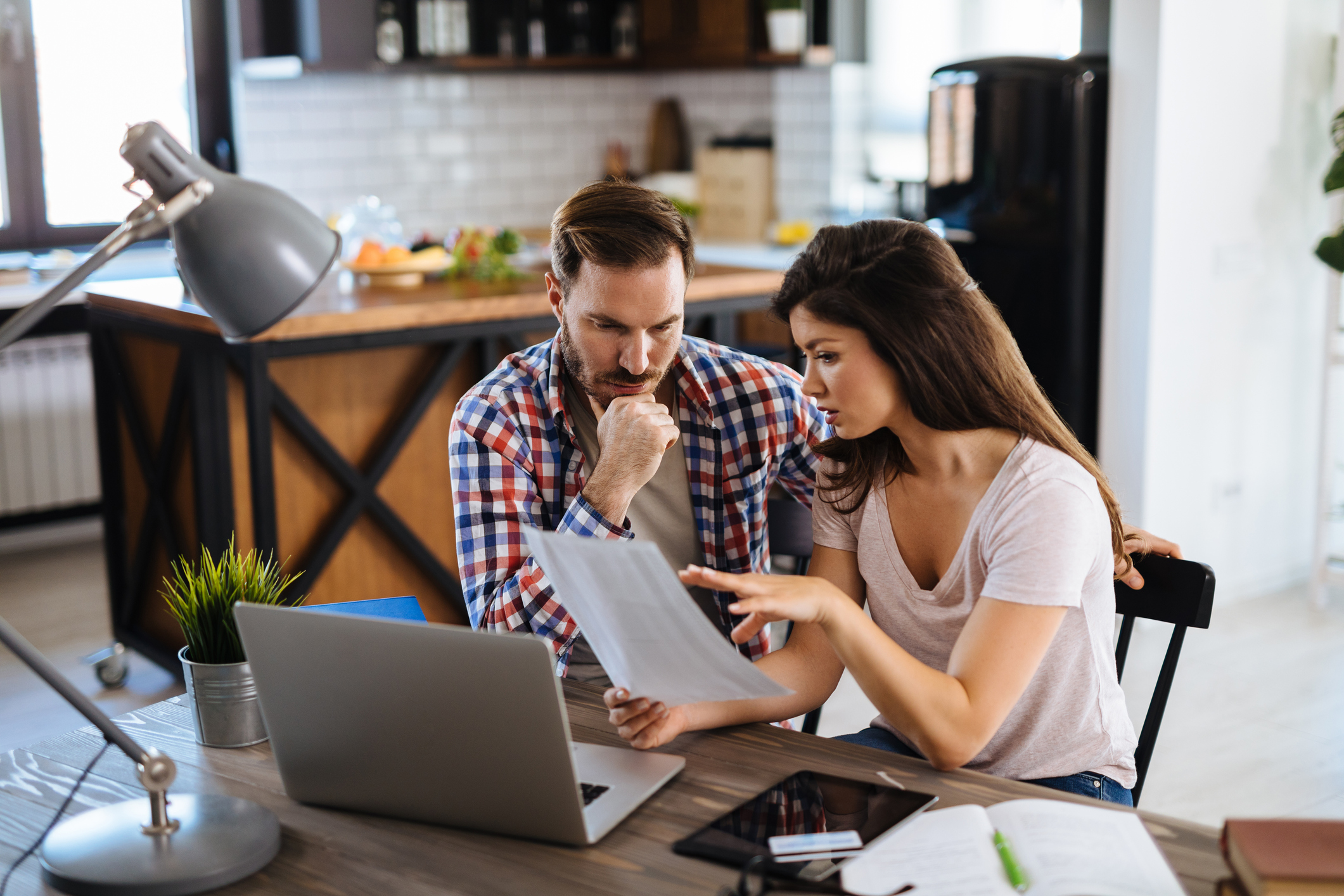 Two people in a house review paperwork together.