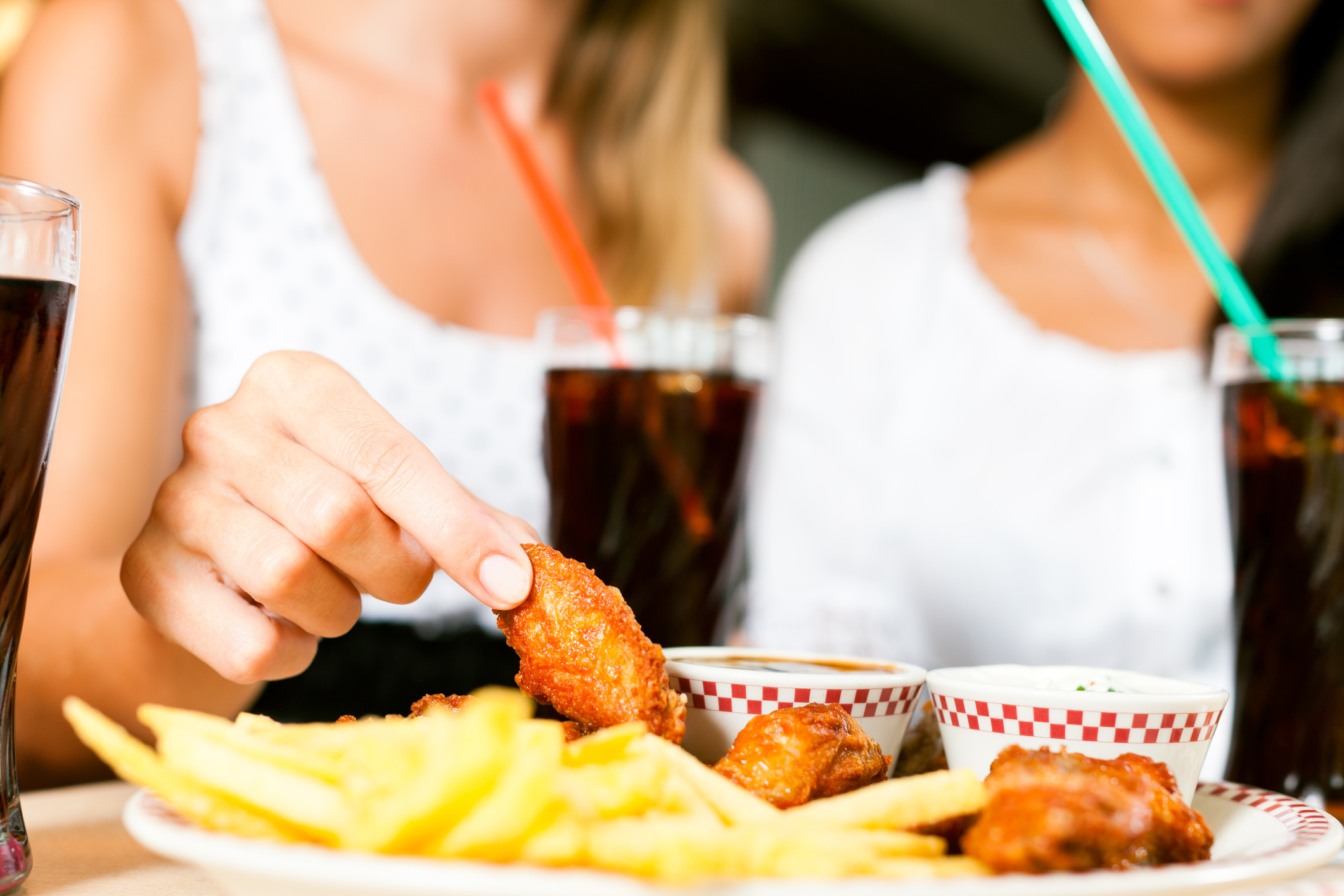 A woman holding a chicken wing.