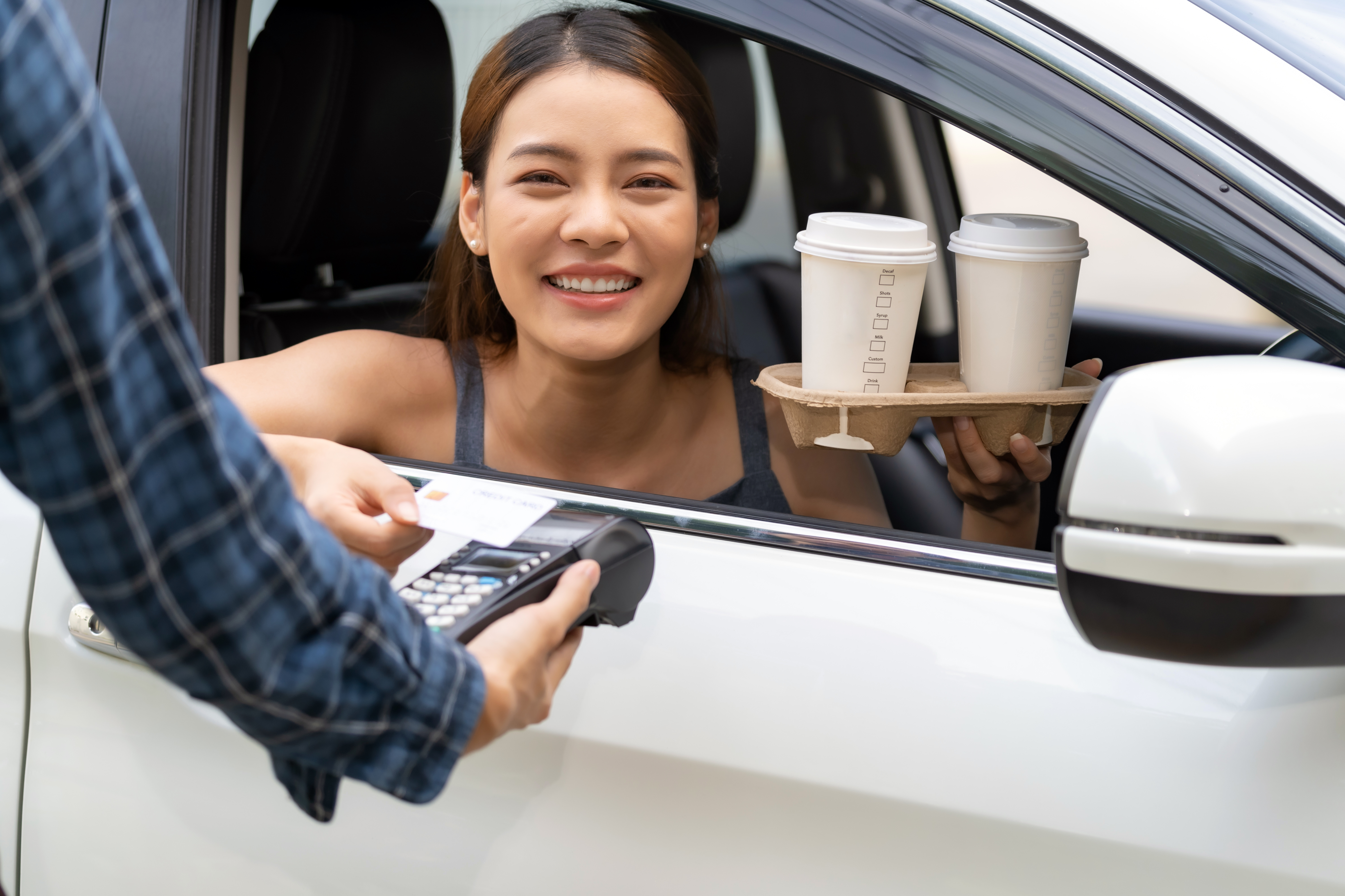 A person getting coffee at a drive-thru.