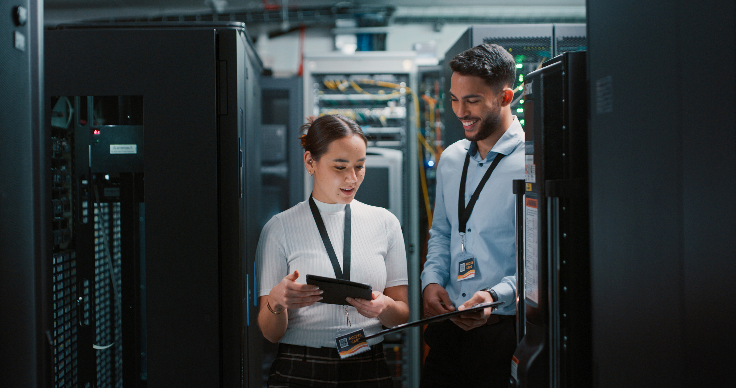 Two colleagues working together in a server room.