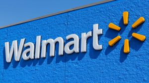 Image of Walmart (WMT) logo on Walmart store with clear blue sky in the background