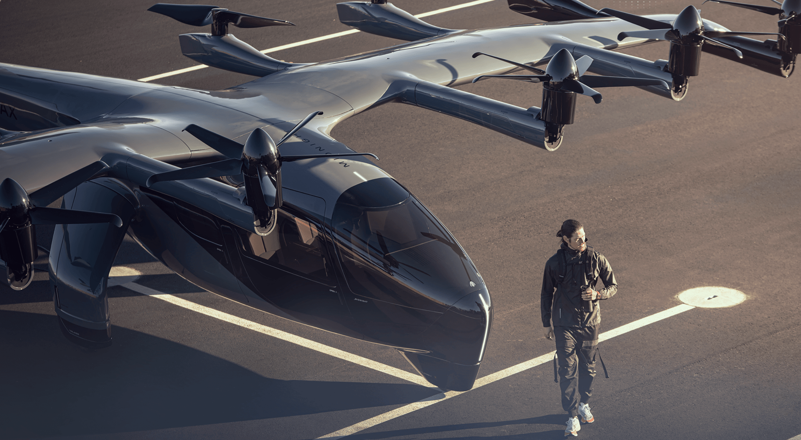 A pilot walks in front of Archer Aviation's midnight aircraft.