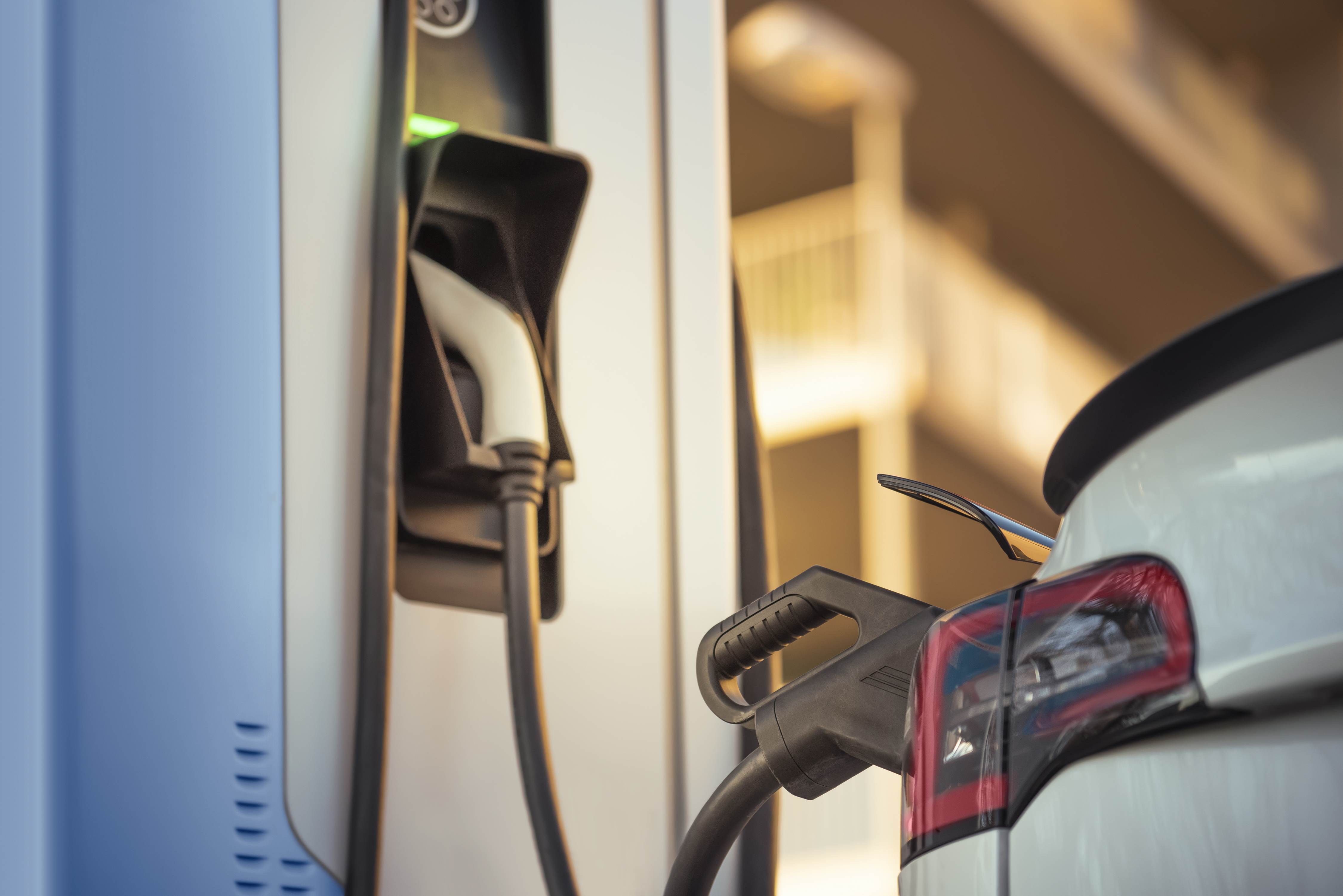 Electric vehicle charging at a charging station. 