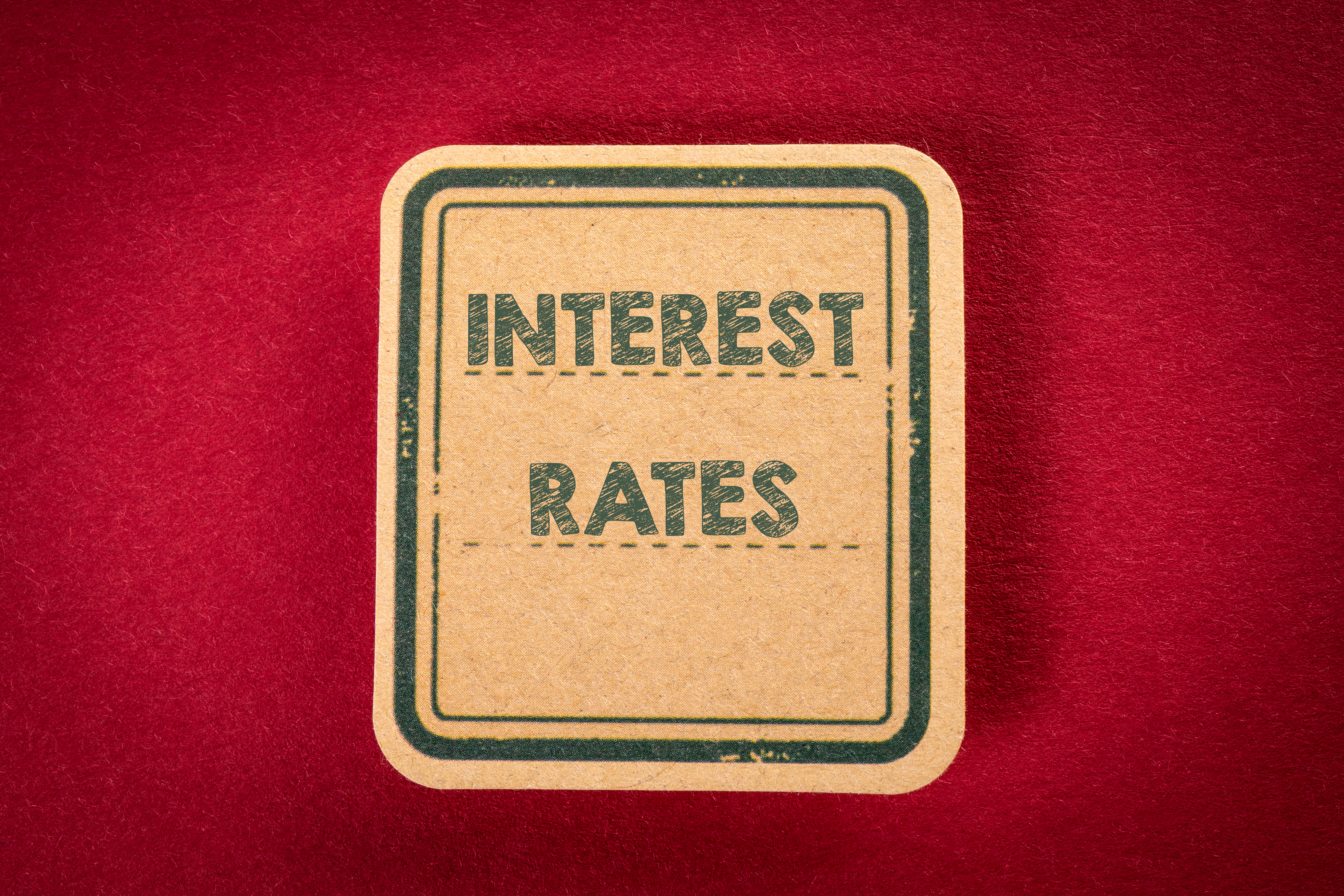 The words Interest Rates written on a sign against a red background.