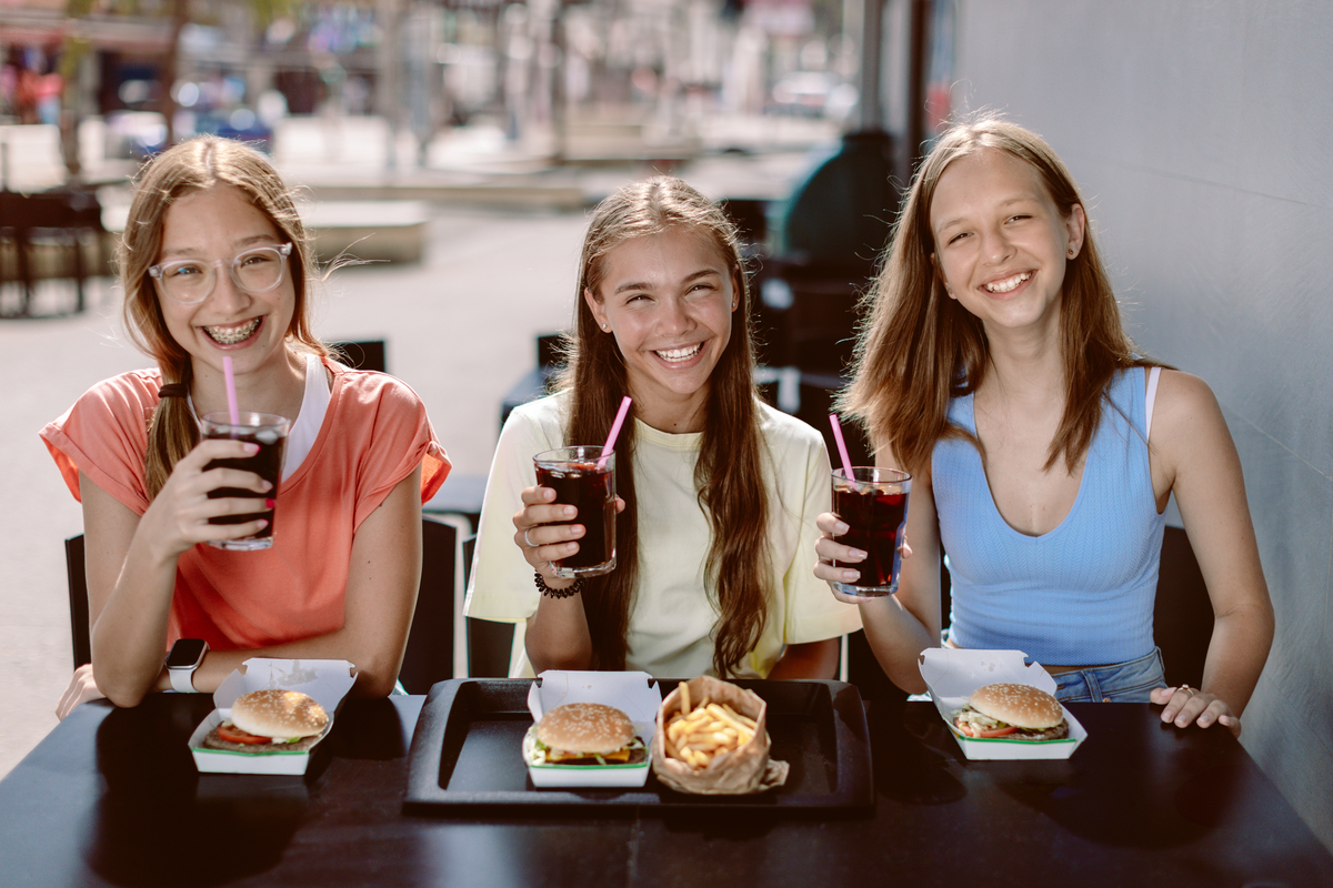 Three people holding drinks.