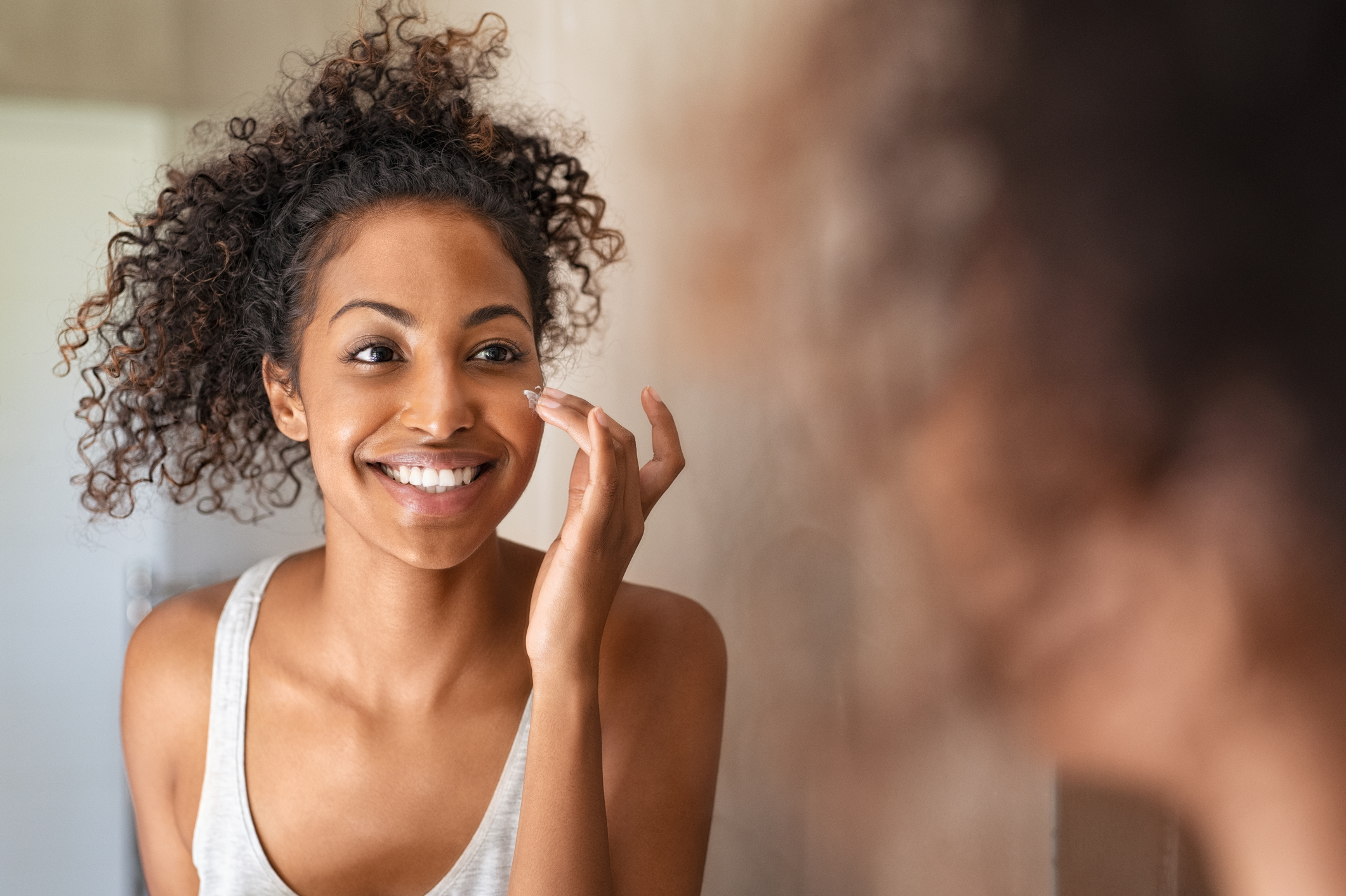 A person putting on makeup in front of a mirror.