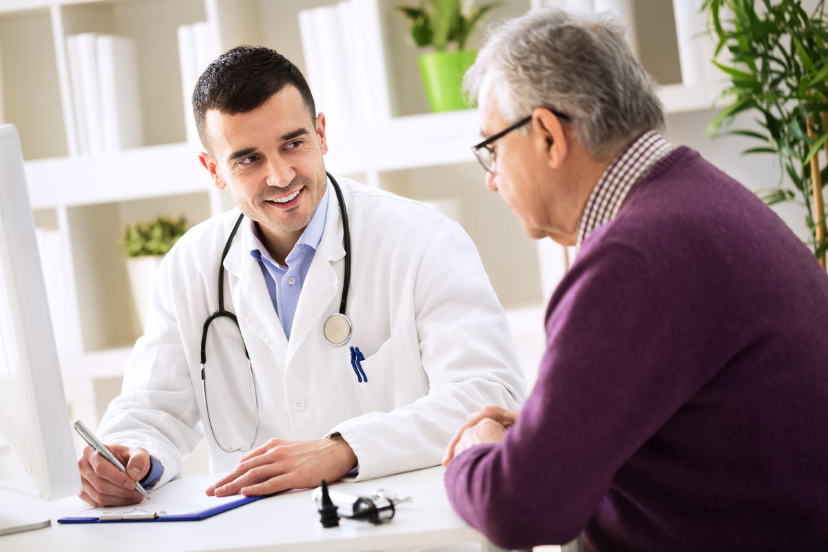 Smiling doctor talking to patient in office.