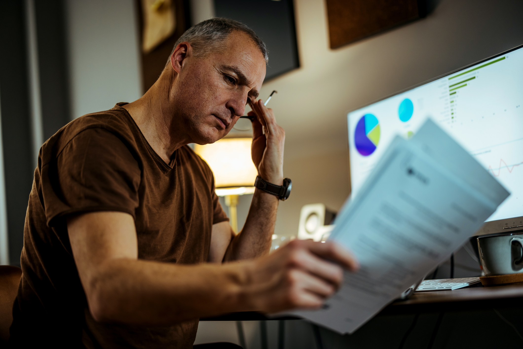 A person with a serious expression while looking at documents.