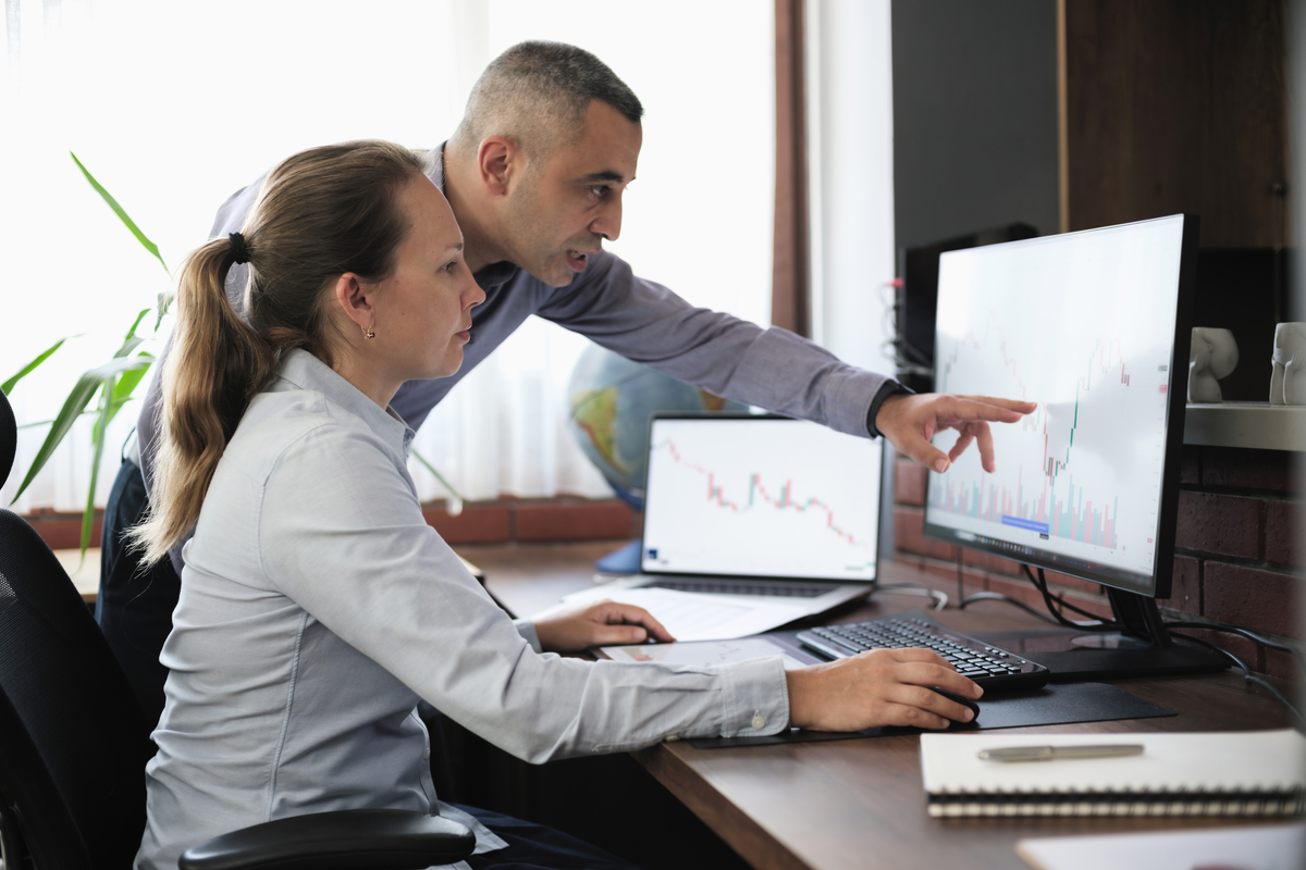 Two people looking intently at a laptop screen.