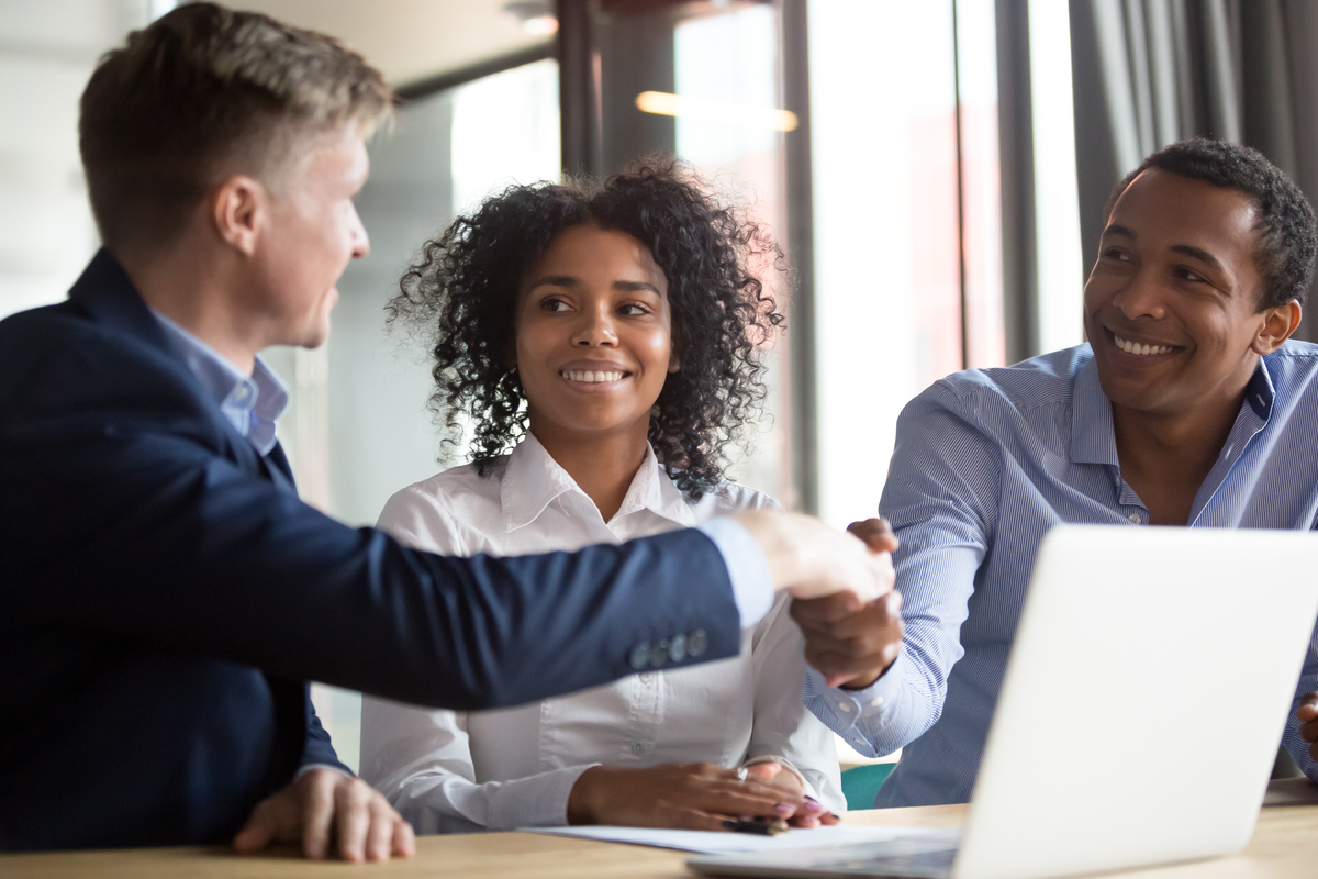 Group of 3 people interacting in a professional office environment.