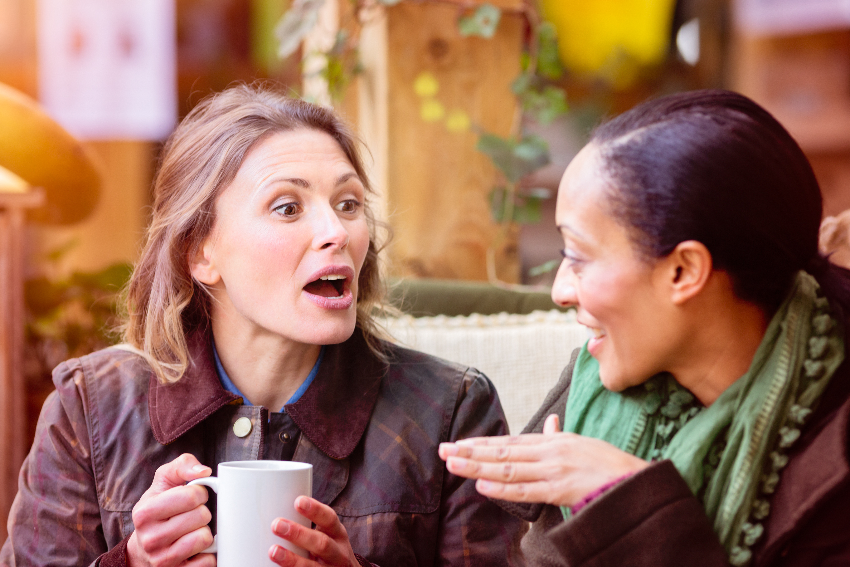 Two friends sharing secrets over coffee.