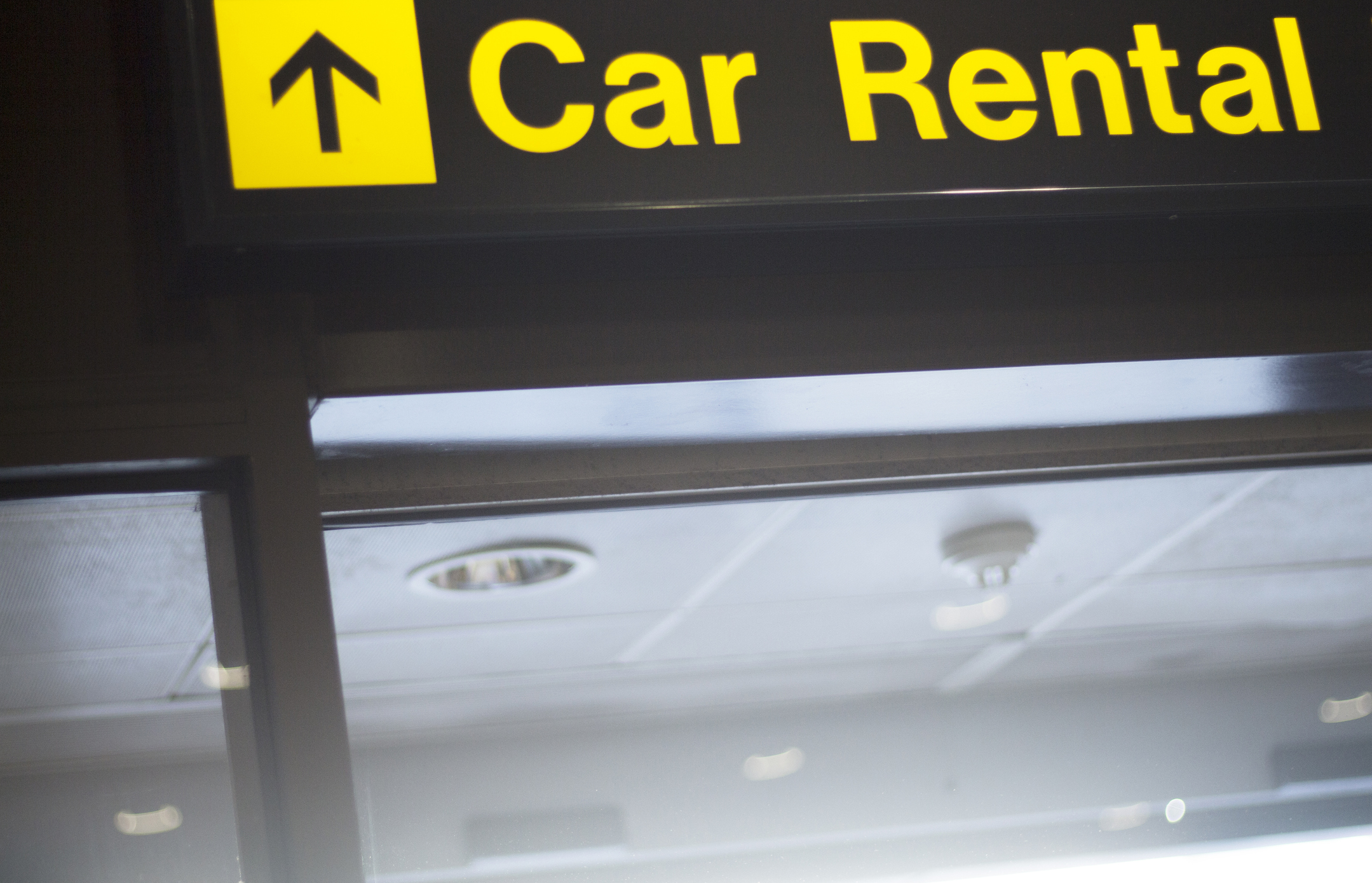 A sign for car rental in an airport.