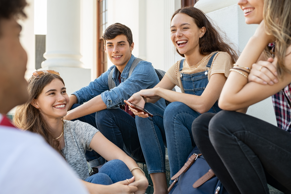 Group of young people in a seated position interacting with vibrant expressions.