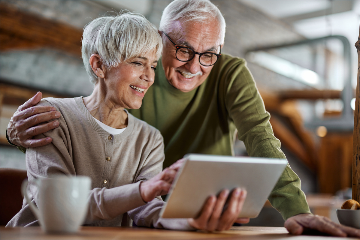 Smiling couple looking at tablet together.