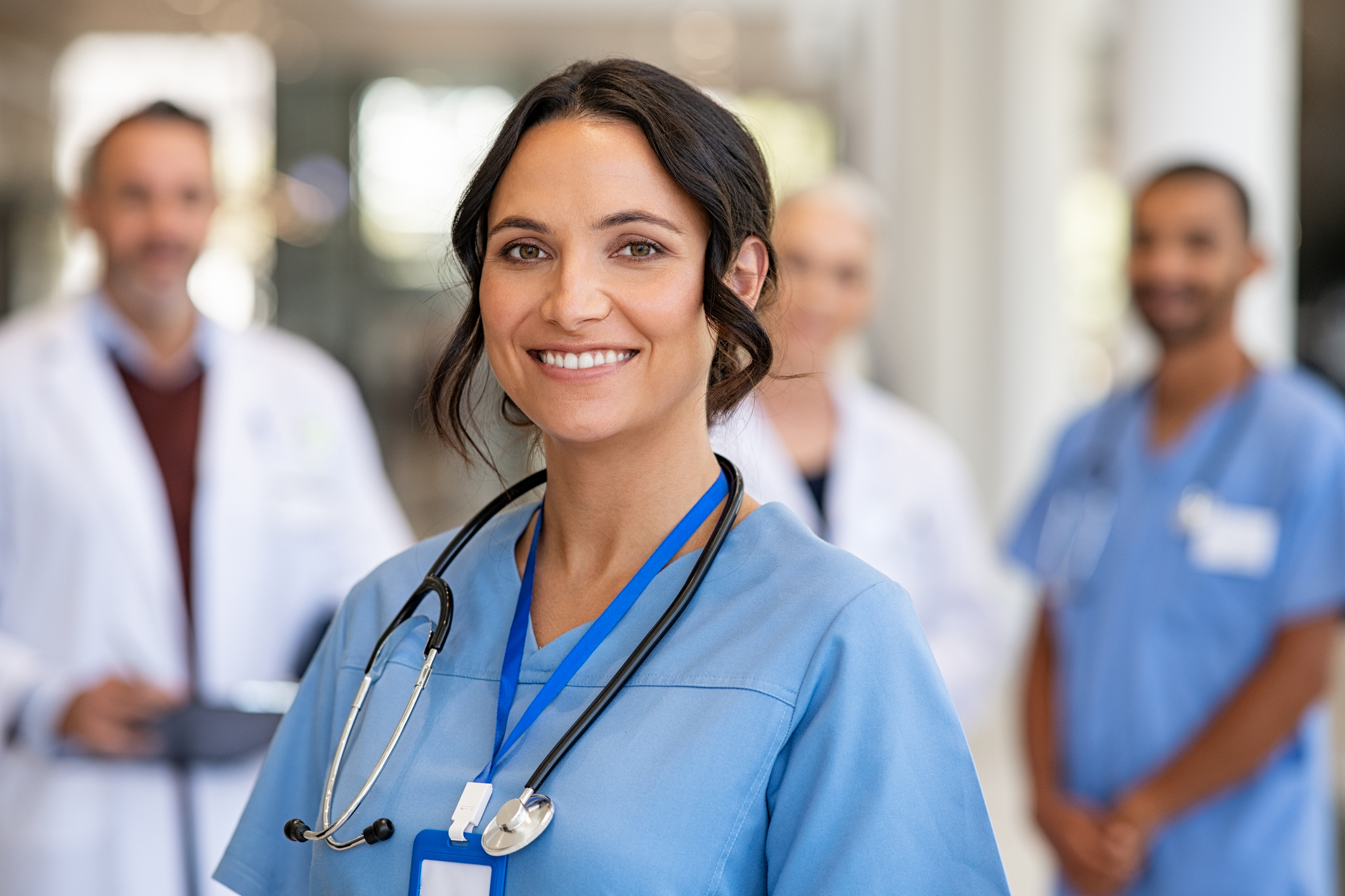 A healthcare worker standing in front of other healthcare workers. 