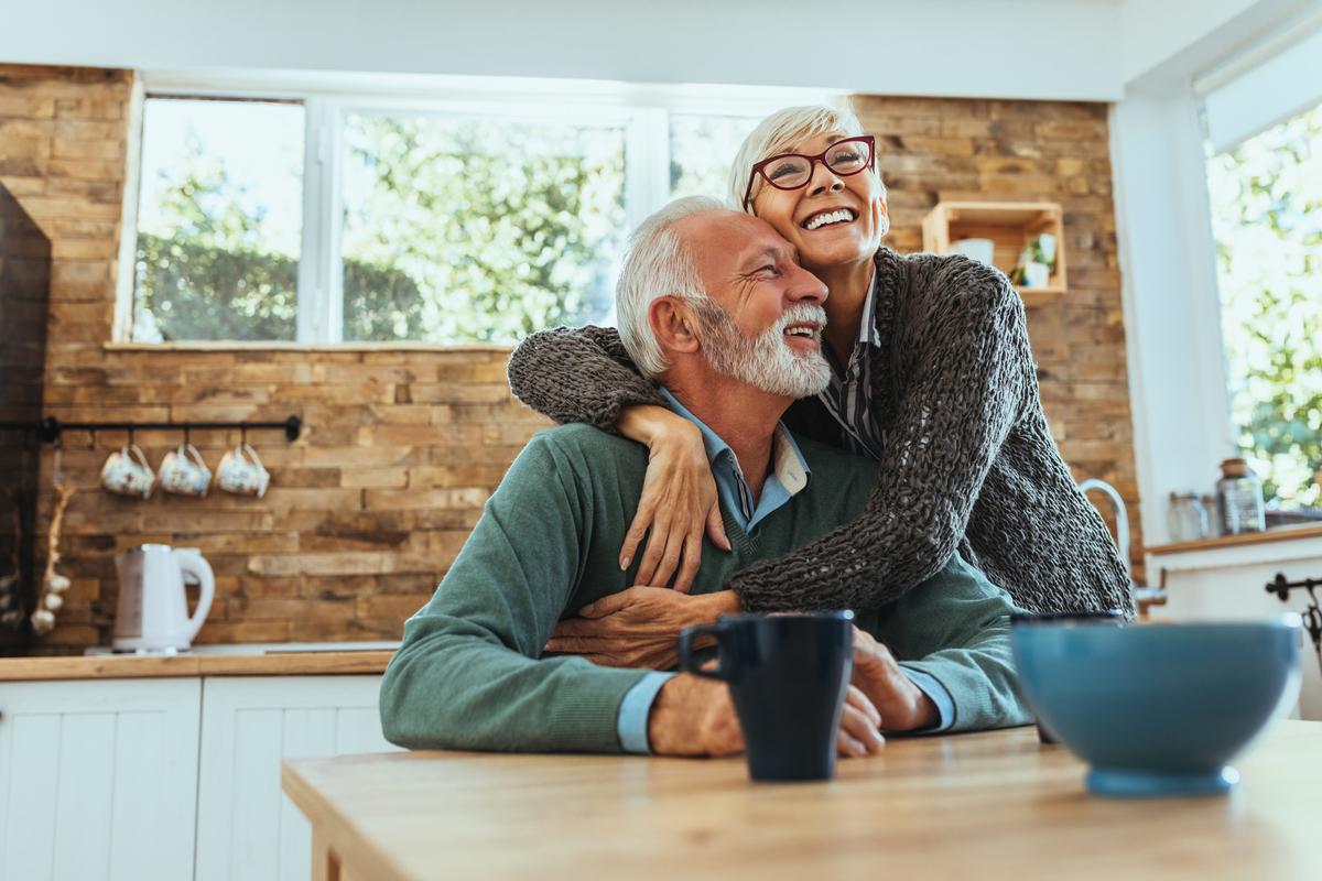 Smiling couple embracing in the kitchen.