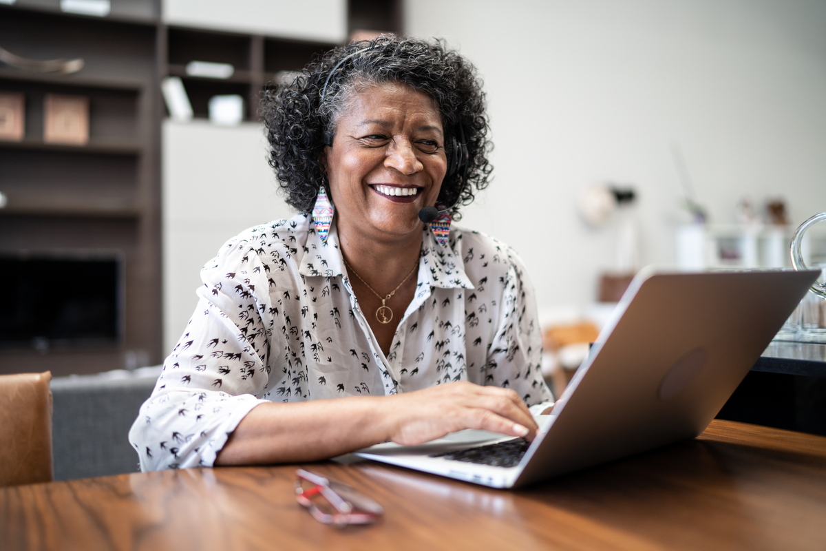 Smiling person using laptop.